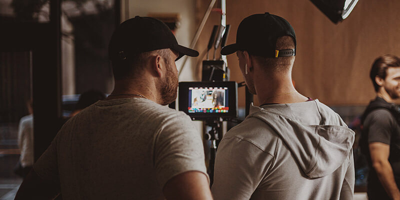 Technicien en imagerie numérique-DIT-Footage Un technicien en imagerie numérique et un directeur de la photographie visionnent des séquences sur un petit écran.