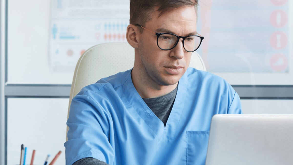un médecin travaille sur son ordinateur portable