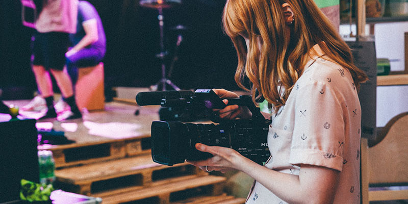 cámara de cine lateral Una mujer utiliza una cámara de cine panasonic que alquiló a un profesional de la producción de vídeo