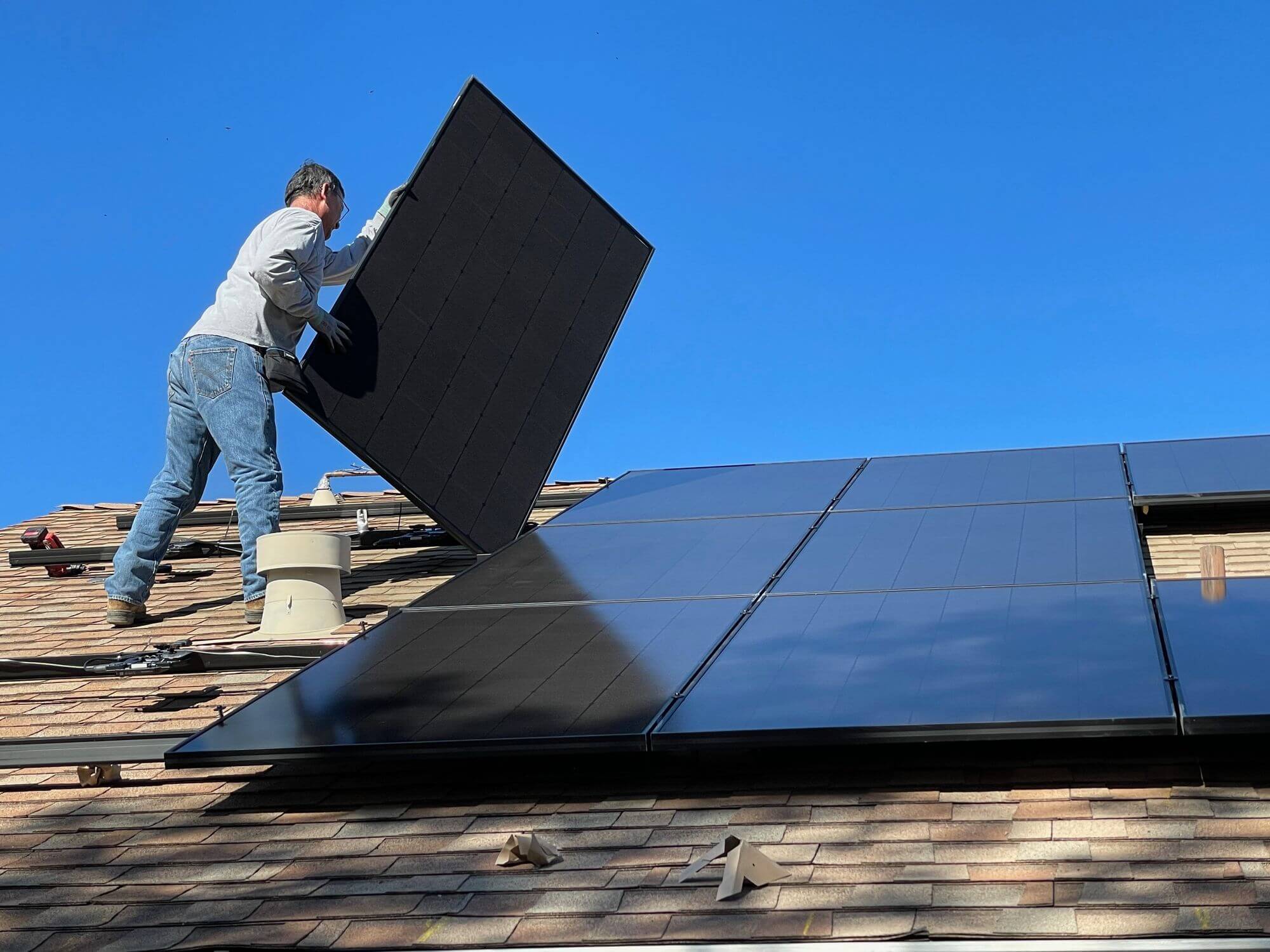 Panneaux solaires Un homme installe des panneaux solaires