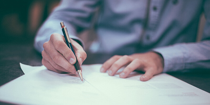 travailler-avec-des-clients-en-facturant Un homme remplit une facture pour un client.