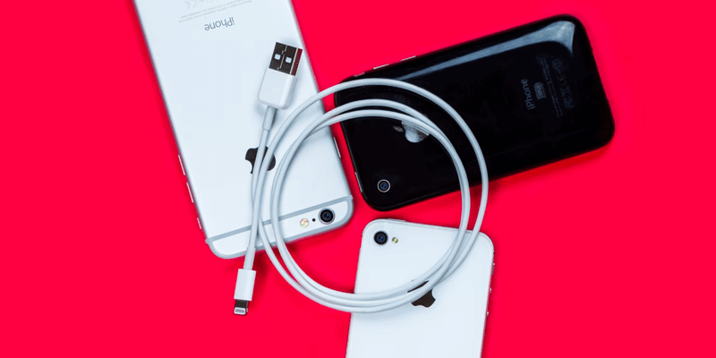 Fichiers ProRes de l'iPhone 13_câble éclair Un câble Apple Lightning est posé sur trois iPhones.
